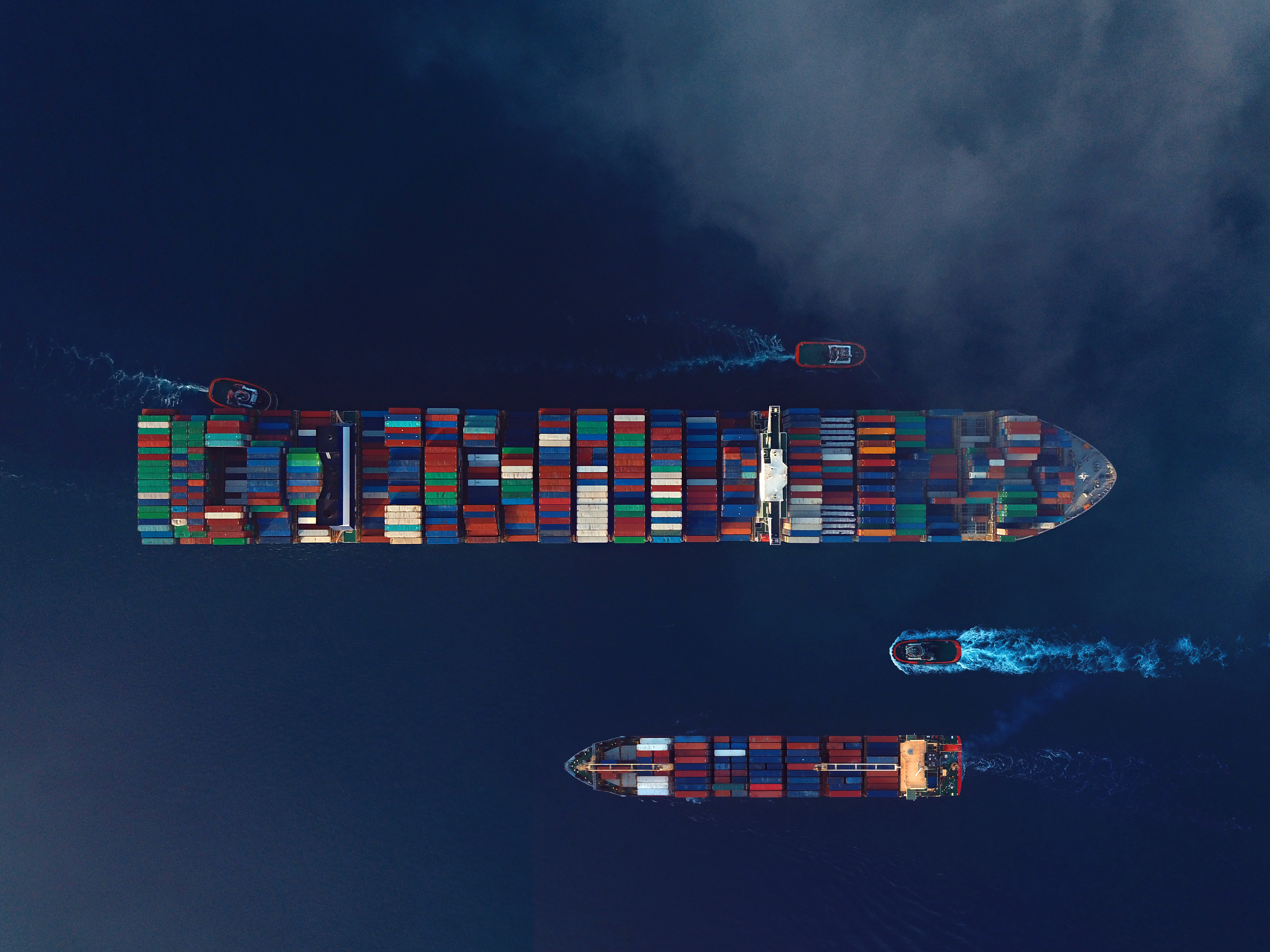 Directly above view of two cargo ships. High freight rates cast a shadow over economic recovery.