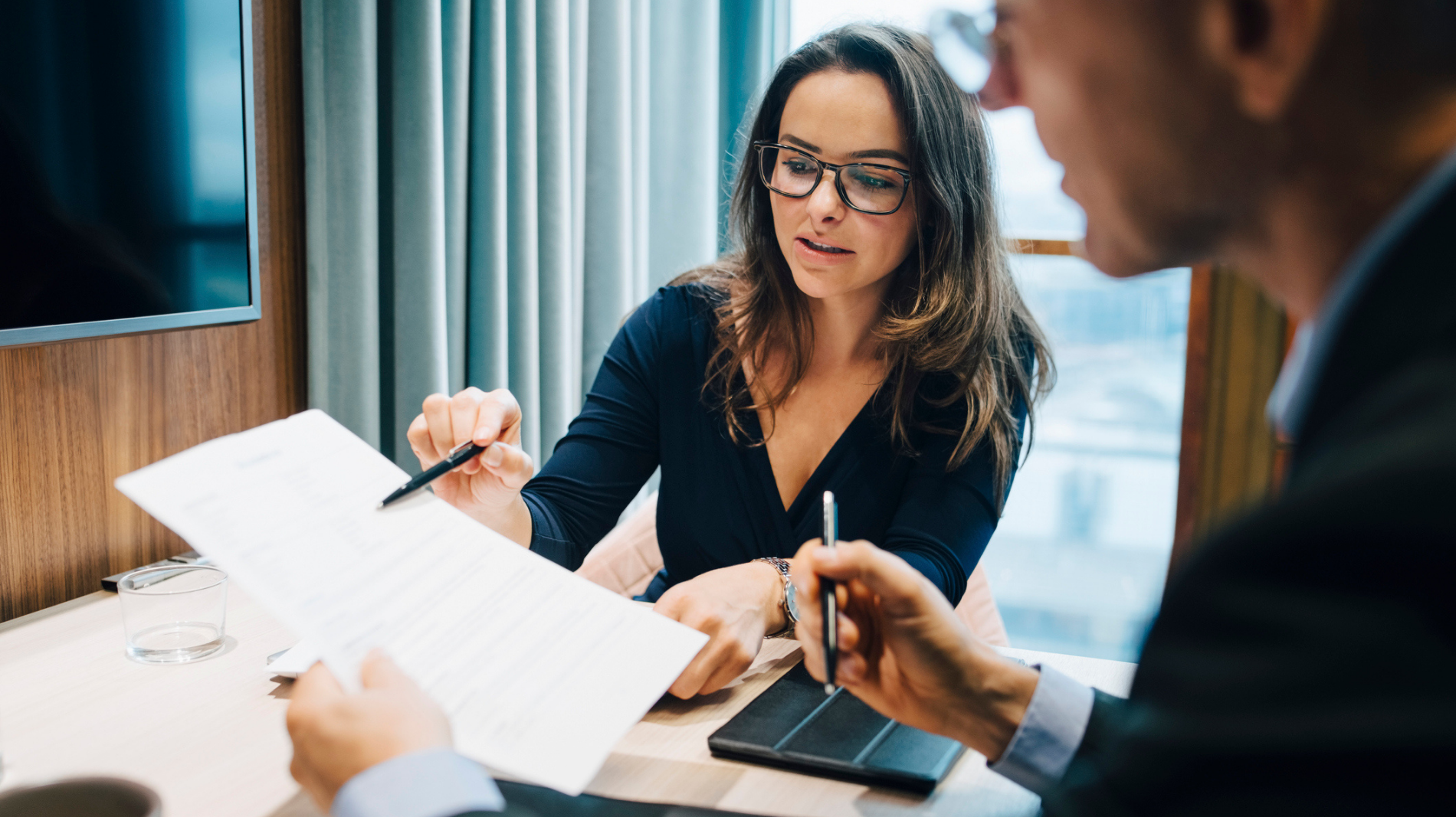 Male and female looking over document during meeting in office