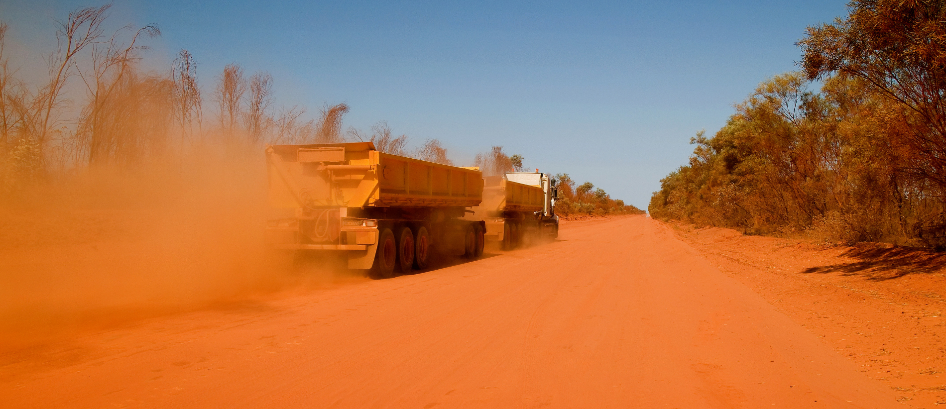 Truck in Australian outback kicking up red dust, motor fleet