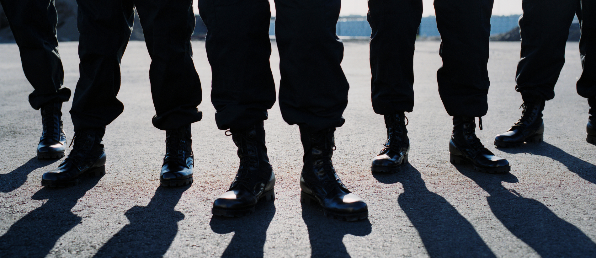 Group of males standing together, legs and boots visible with shadow, army, kidnap and ransom, special forces, military