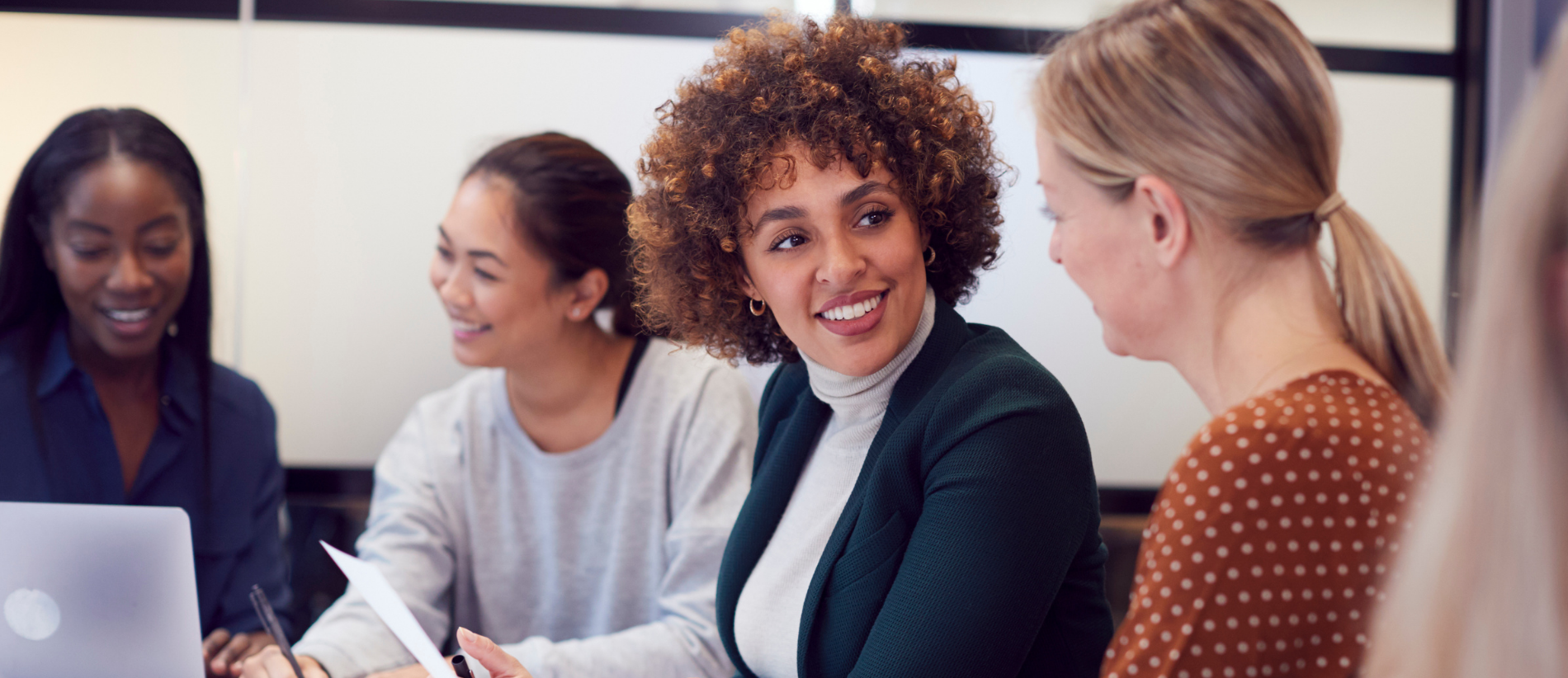 Group Of Businesswomen Collaborating In Creative Meeting Around Table In Modern Office