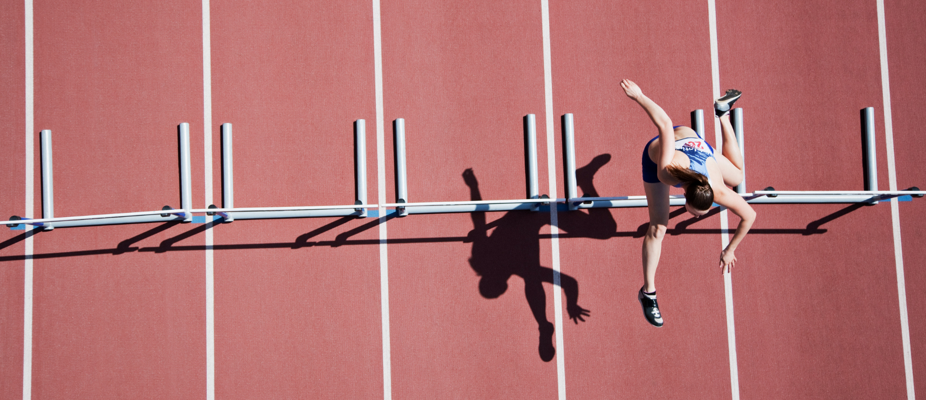 Runner jumping hurdles on track