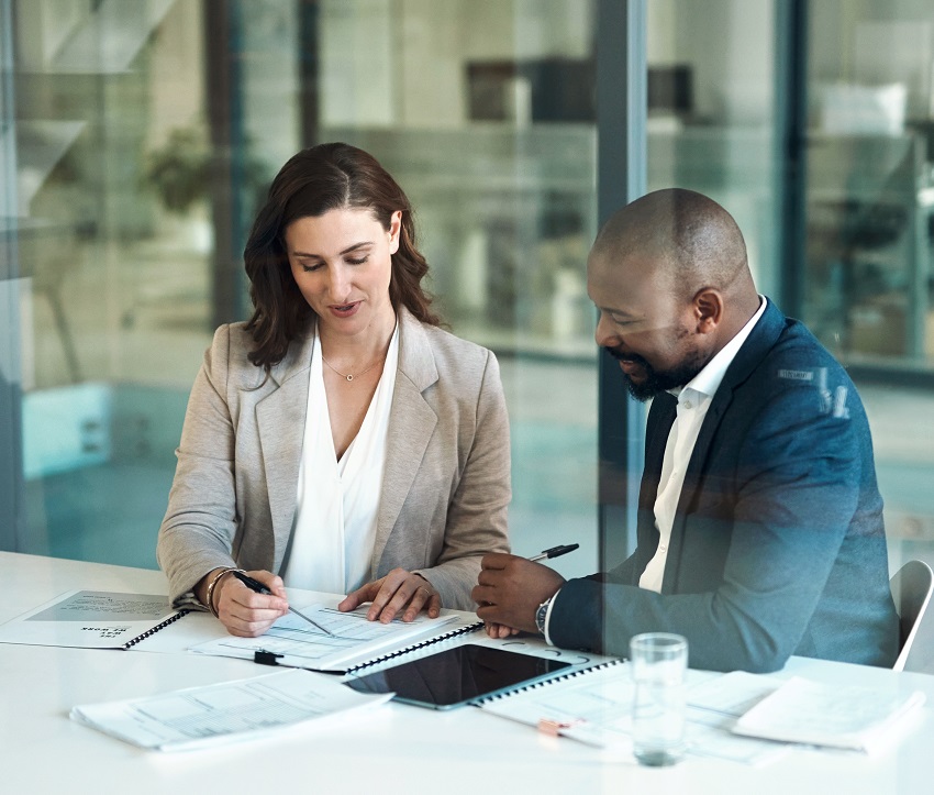 Office, meeting and documents of business people, clients or team for taxes, audit or revenue report in accounting. Paperwork, review and advice of woman, financial advisor or accountant support