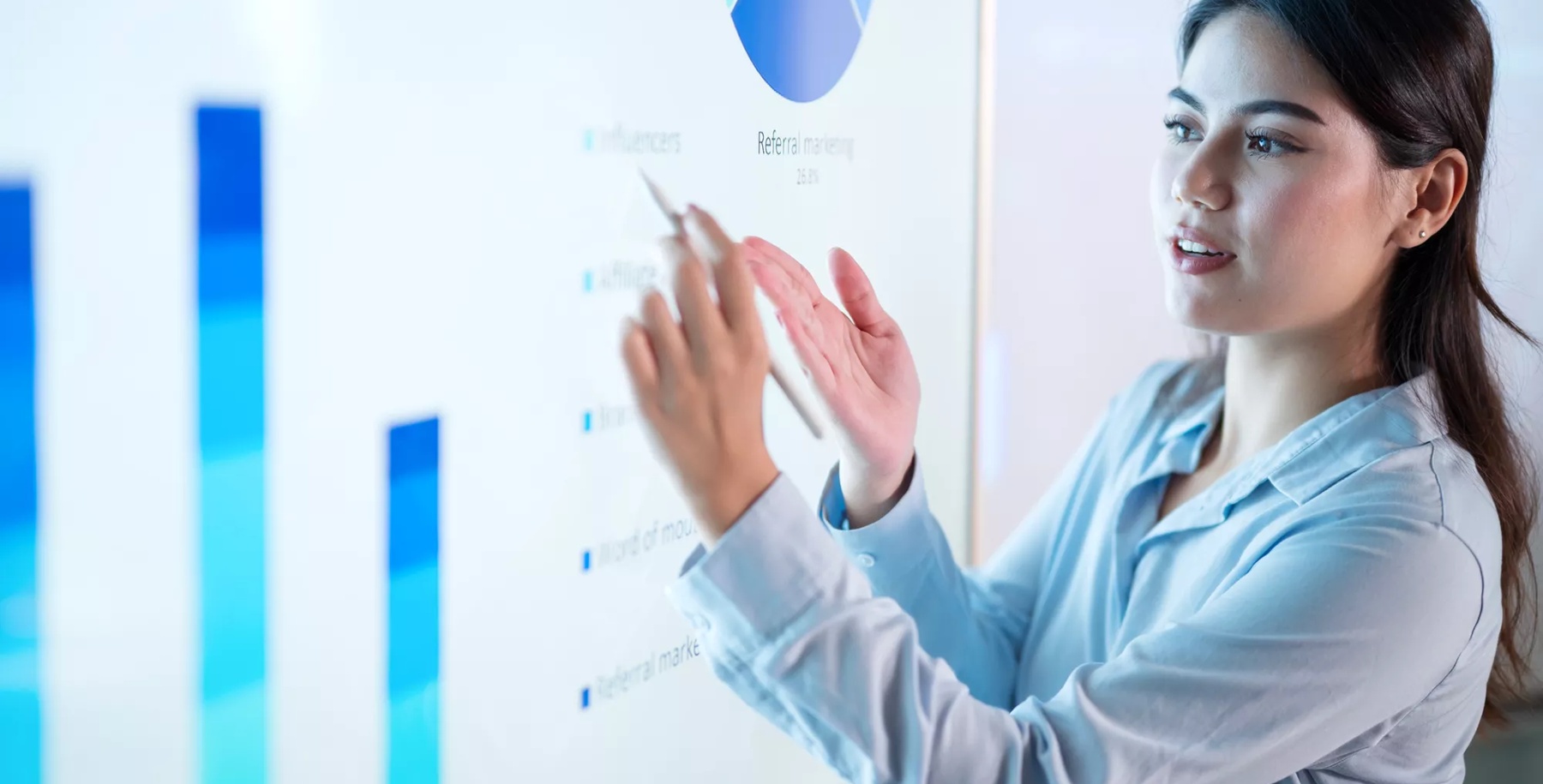 Cash Flow Management Is Key To Business Success. A female chief financial officer on a business plan meeting to explain a financial info-graphic on an interactive screen to her colleagues in a modern business office.