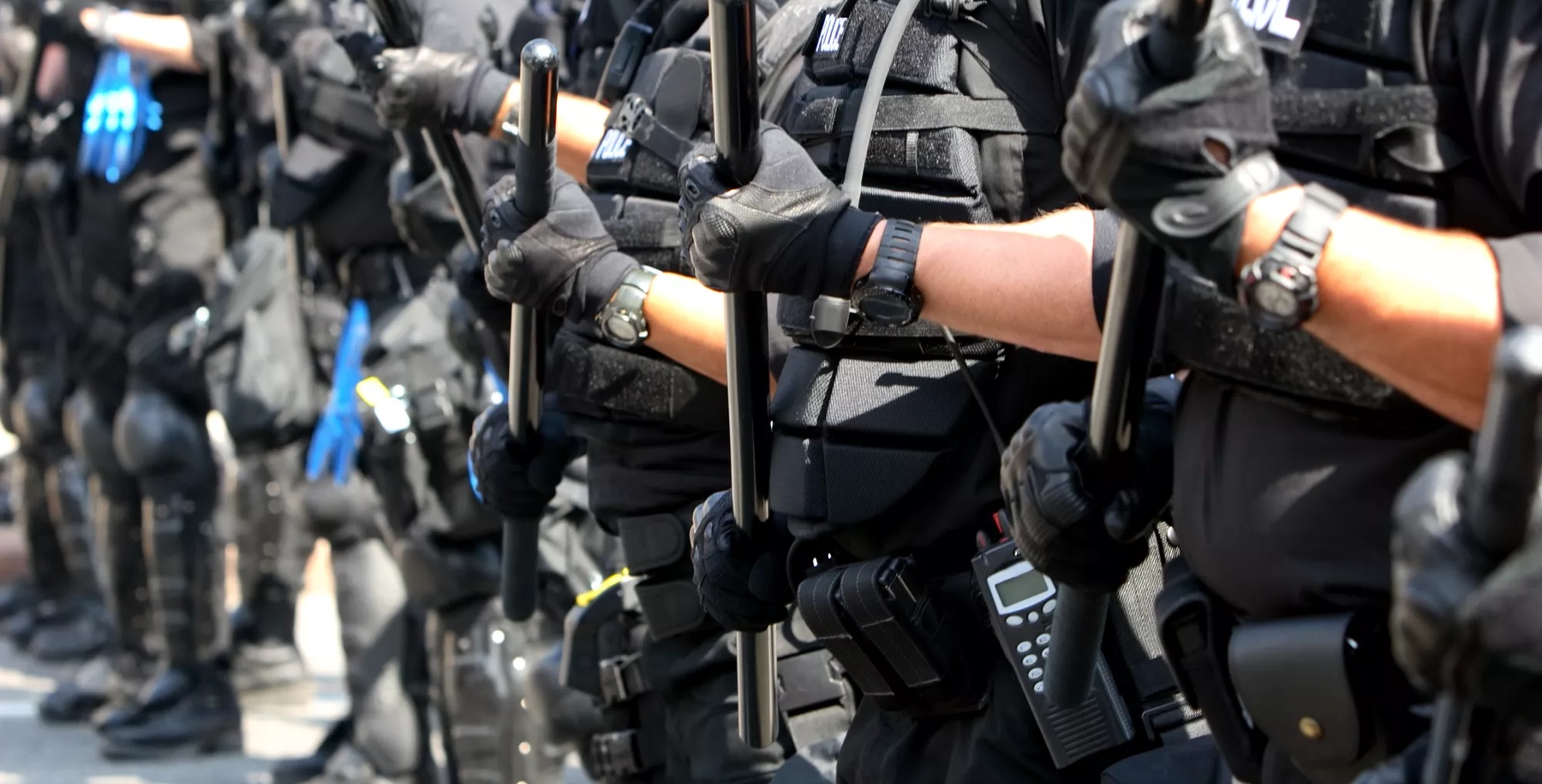 Police forming a line during a public disturbance.