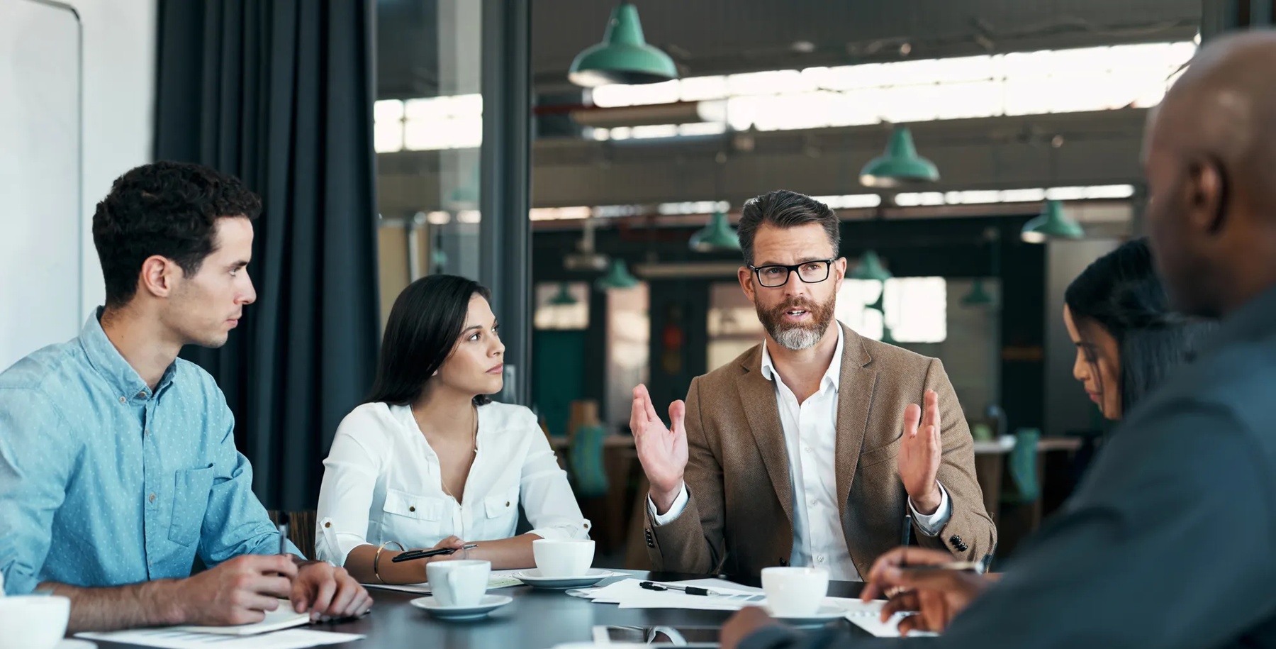 Business people, meeting and planning in team conference for marketing strategy, ideas and discussion at the office. Group of diverse corporate employee workers in teamwork conversation for sales