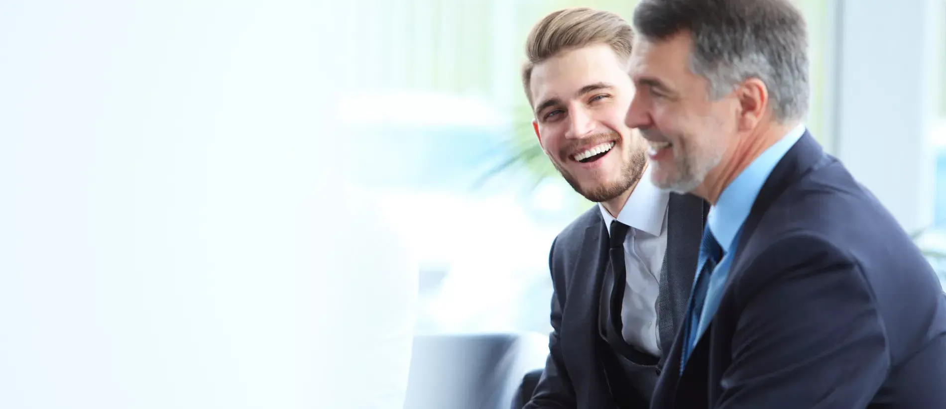 Two male businessmen in conversation laughing