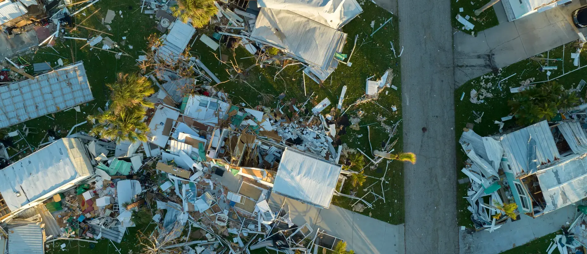 Hurricane destroyed suburban houses roofs in Florida mobile home residential area. Consequences of natural disaster.