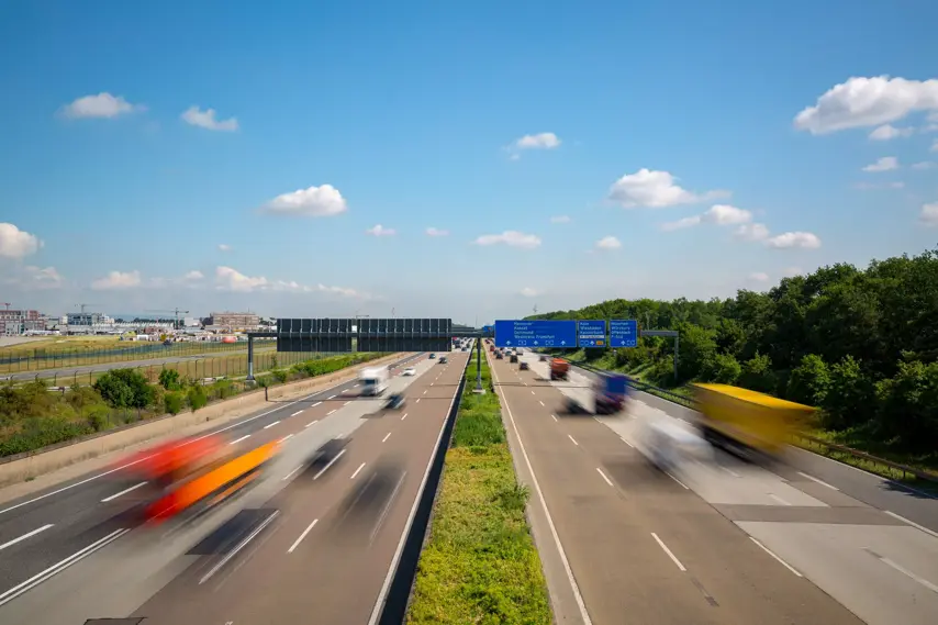 Multilane Autobahn highway with blurred trucks and cars near Frankfurt Airport, Frankfurter Kreuz, Germany. Transportation.