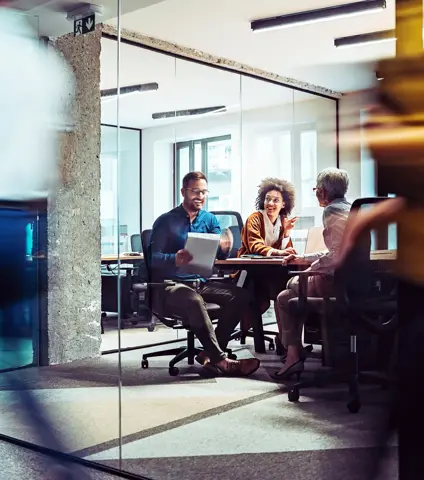Group of business persons having a meeting in a closed glass conference room