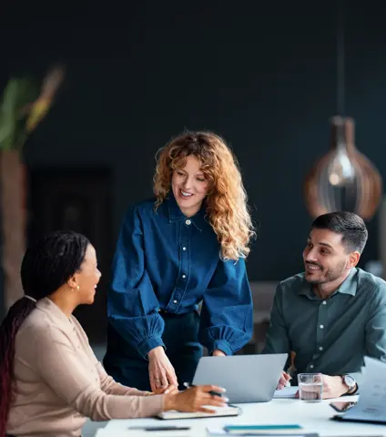 A diverse group of coworkers collaborate in a modern office, illustrating teamwork and productivity. The image depicts professional interaction, technology use, and a positive workplace atmosphere.