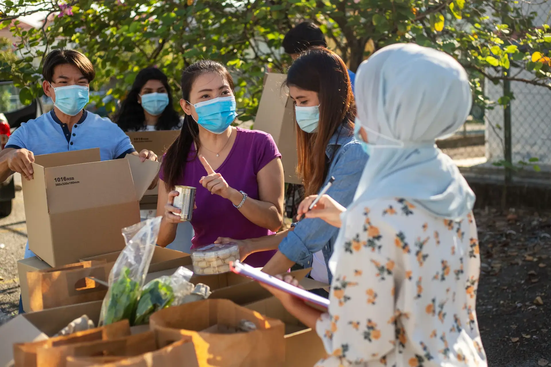 Group of charity workers working together, help collecing food for homeless victims