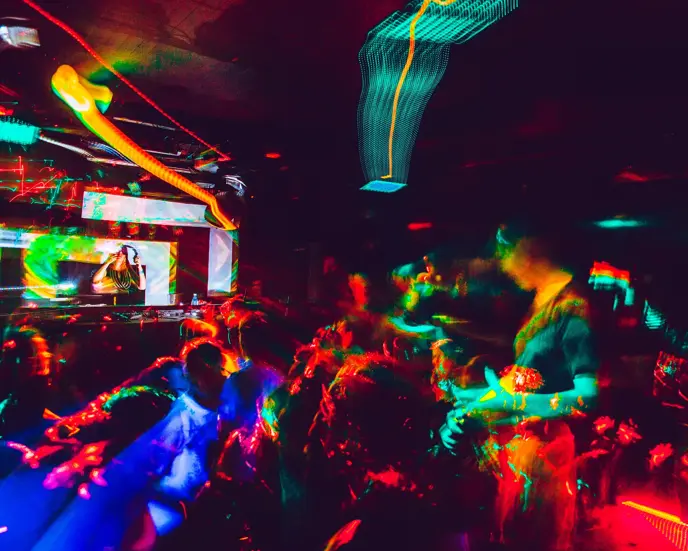 People Dancing in Nightclub and Young Woman DJ Performing.