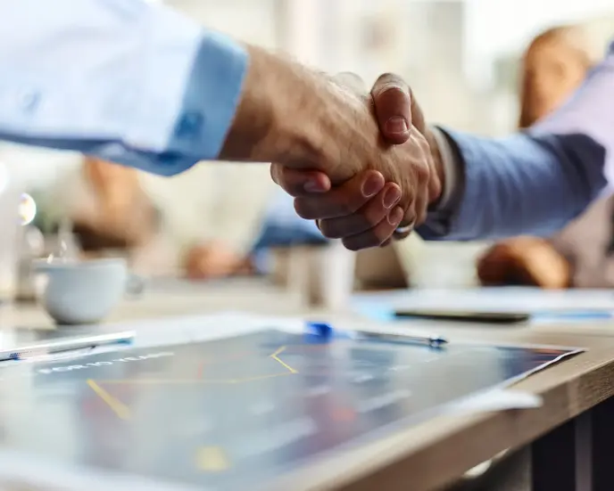 Close up of unrecognizable male entrepreneurs shaking hands during a meeting in the office.