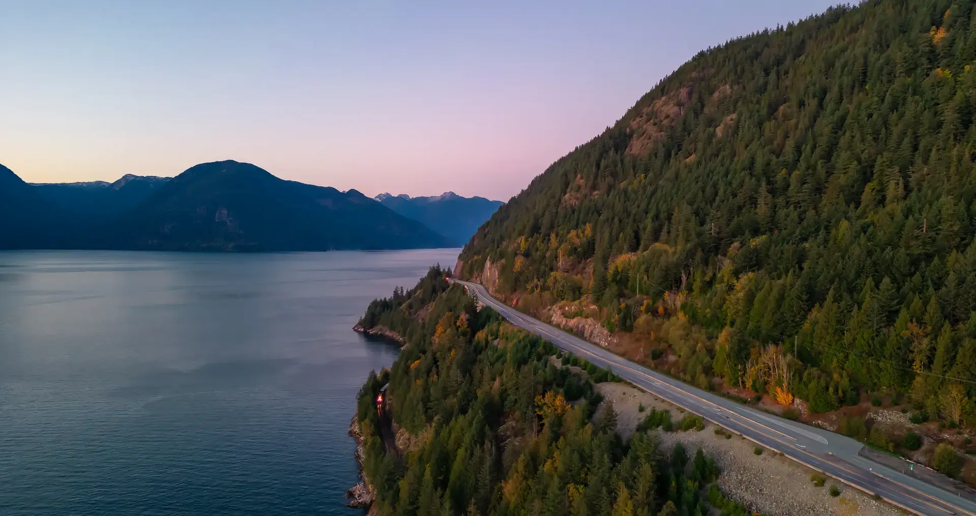 Sea to Sky Highway on West Coast of Pacific Ocean. Aerial Mountain Landscape. Twilight sky. Howe Sound, BC, Canada.