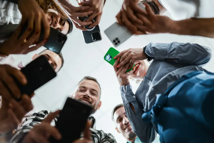 Low Angle View Of Modern Business Team Using Smartphones To Photograph