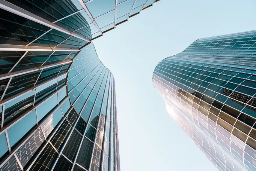 Low angle view of a curved building with glass and steel facade in Barcelona, Spain.