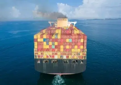 Ship in the ocean with smokestack and smoke.