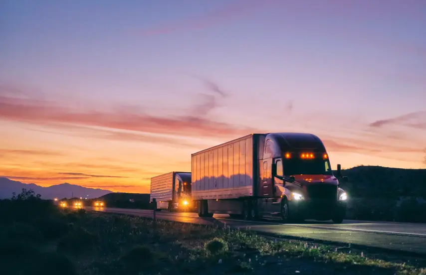 Large semi truck hauling freight on the open highway under an evening sky, sunset, fleet