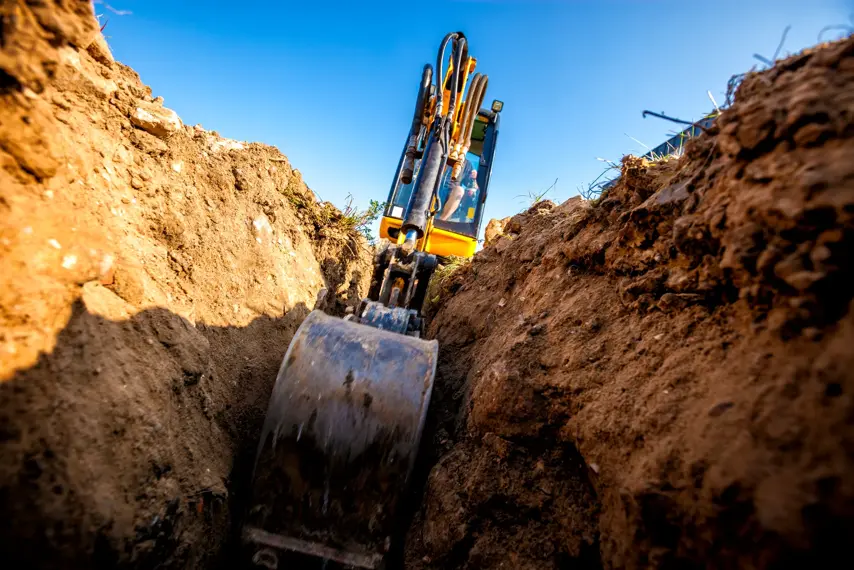 Mini Excavator. Excavator digs the foundation for the house.